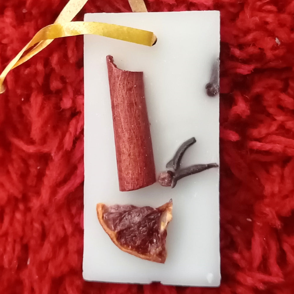 oranges on a white stone slab with a yellow ribbon against a red textured background wax decoration