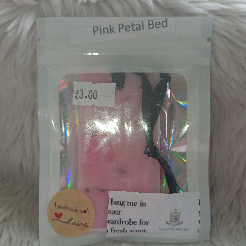 pink wardrobe freshener in a white and transparent packaging with a white fluffy background